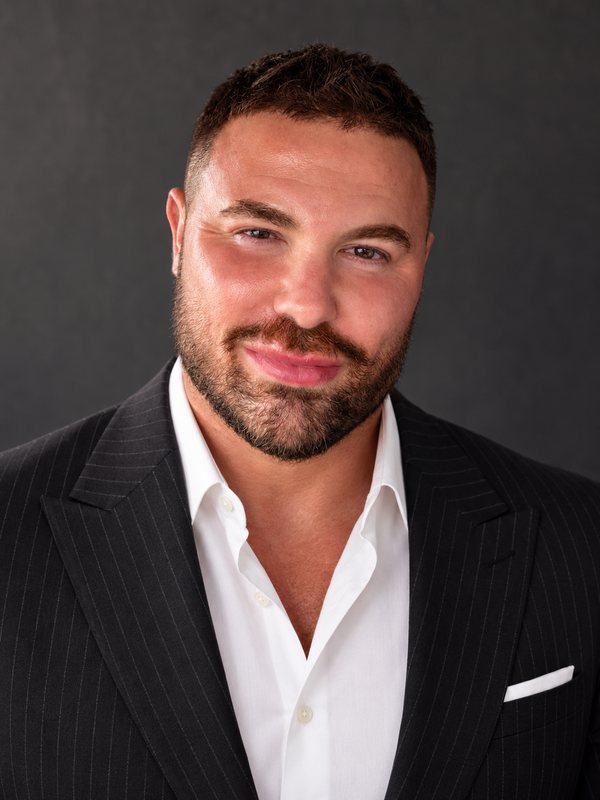 Jason Rosenberg in a dark pinstripe blazer and white shirt, smiling